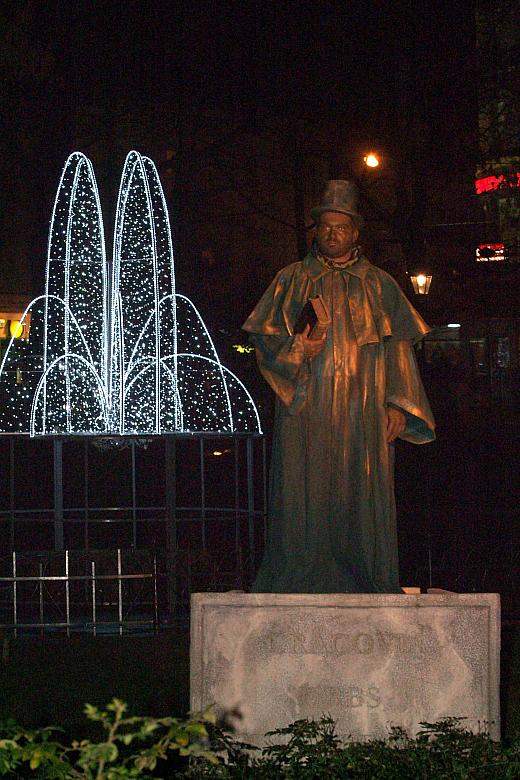 ...a stojąca na postumencie postać pozdrawiała przechodniów..