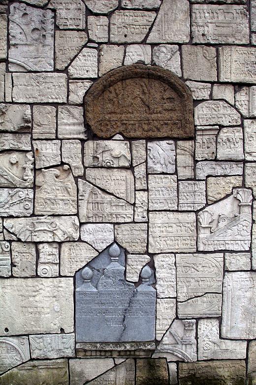 Mur cmentarny z resztkami nagrobków zniszczonych przez barbarzyńskich okupantów ...